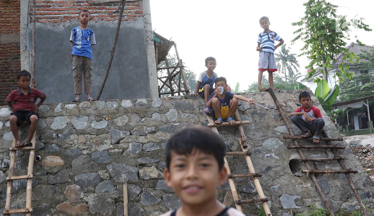 Anak-anak bermain di RPTRA Pelangi Cipedak yang pembangunannya terhenti di Jakarta, Senin (18/3). Terhentinya pembangunan RPTRA yang telah tiga kali mangkrak dikeluhkan warga karena molor dari target yang ditentukan. (Liputan6.com/Immanuel Antonius)