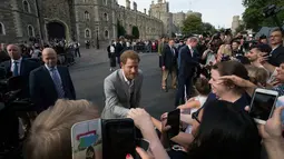 Pangeran Harry menyalami orang-orang di luar Kastil Windsor, Inggris, Jumat (18/5). Pangeran Harry dan Meghan Markle akan menikah di Kastil Windsor. (AP Photo/Peter Dejong)