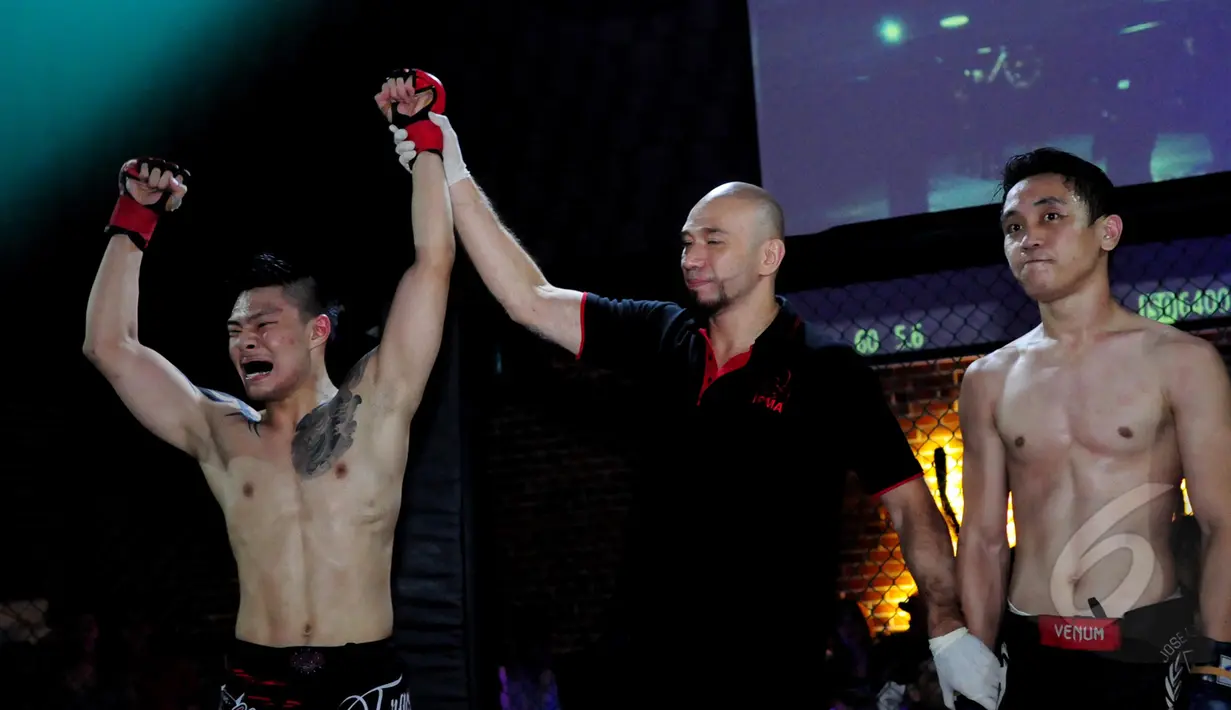 Juri mengangkat tangan salah satu pemenang pada ajang XXC Championship 2015 yang dihelat di Embrio Markas Cafe, Jakarta, Minggu (12/04/15). Kejuaraan memperebutkan gelar Indonesia Extreme Cage Champtionship 2015. (Liputan6.com/Faisal R Syam)