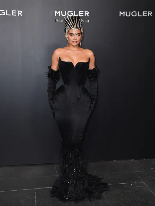 <p>Kylie Jenner tiba pada pembukaan pameran Thierry Mugler: Couturissime di Brooklyn Museum, Brooklyn, New York City, Amerika Serikat, 15 November 2022. Mulai dari pertengahan betis, gaun itu beralih dari kain sutra hitam yang kaya menjadi mahakarya berbulu berkilau yang menggenang di kakinya. (ANGELA WEISS/AFP)</p>