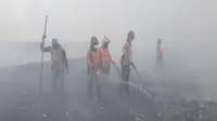 Petugas DLH Solo berjuang memadamkan api dan asap di TPA Putri Cempo Solo, Senin (22/10 - 2018). (Solopos/Nicolous Irawan)