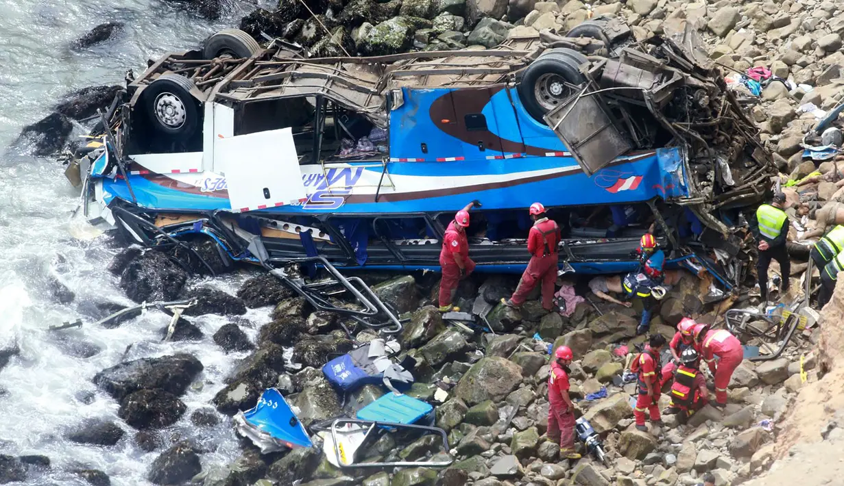 Petugas pemadam kebakaran mengevakuasi tubuh korban dari sebuah bus yang jatuh dari tebing di Pasamayo, Peru, Selasa (3/1). Penumpang bus sebagian besar kembali ke Lima, setelah merayakan liburan Tahun Baru bersama keluarga di luar kota. (HO/ANDINA/AFP)