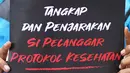Seorang pengunjuk rasa membawa poster saat menggelar aksi di depan Gedung Polda Metro Jaya, Jakarta, Senin (7/12/2020). Massa menuntut aparat kepolisian segera menangkap Rizieq Shihab atas dugaan pelanggaran protokol kesehatan beberapa waktu lalu. (Liputan6.com/Immanuel Antonius)