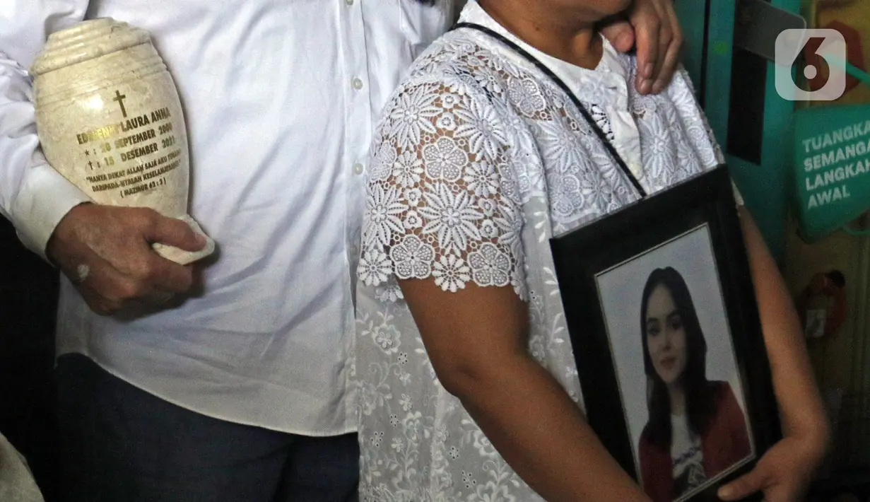 Orangtua selebgram Edelenyi Laura Anna membawa guci dan foto mendiang saat upacara tutup peti jenazah di rumah duka Grand Heaven Pluit, Jakarta Utara, Kamis (16/12/2021). Laura Anna meninggal dunia pada 15 Desember 2021 di Eka Hospital, Cibubur, Jakarta. (Liputan6.com/Herman Zakharia)