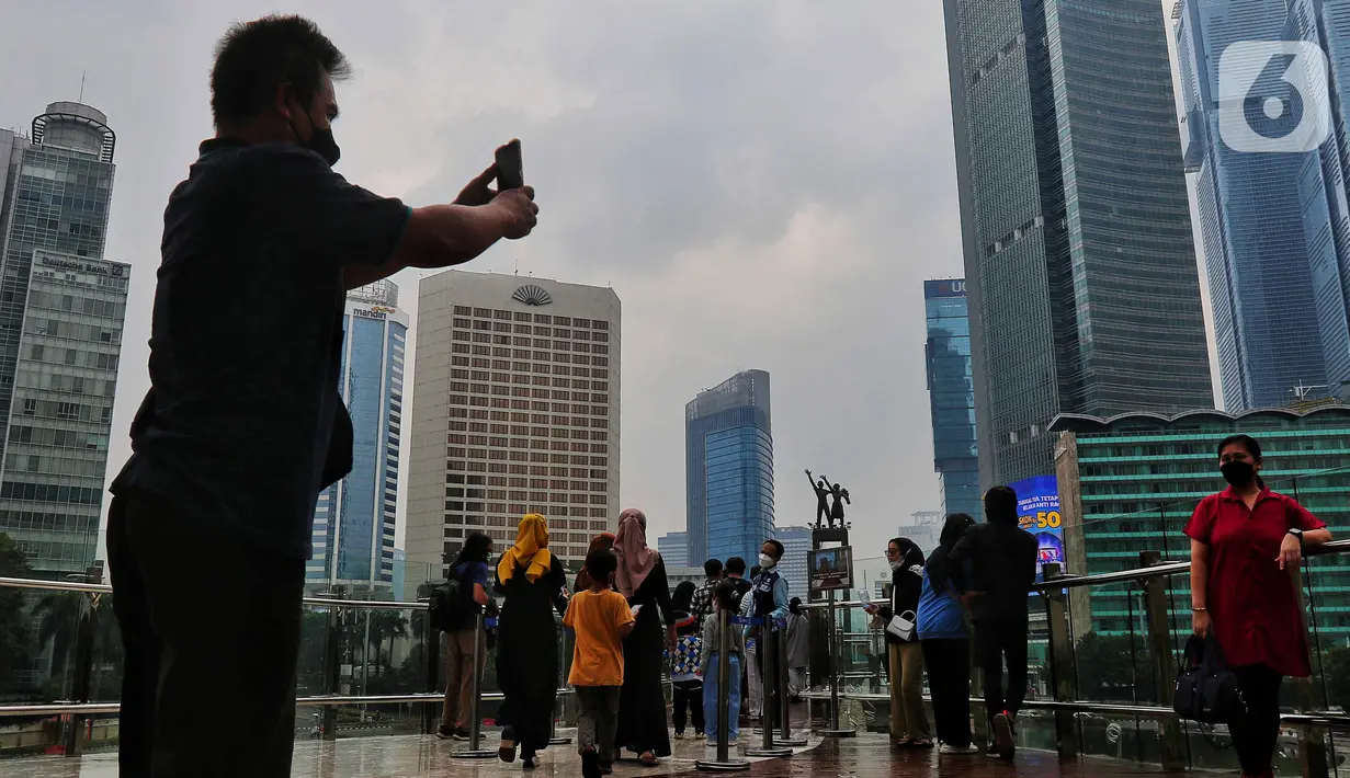 Sejumlah warga berfoto dan antri di anjungan Halte Transjakarta Bundaran HI , Jakarta, Minggu (16/10/2022). Anjungan yang berada di lantai dua Halte Transjakarta Bundaran HI ini dapat menampung 20 orang dan menjadi spat foto baru dengan latar belakang Patung Selamat Datang dan air mancur Bundaran HI. (Liputan6.com/Angga Yuniar)