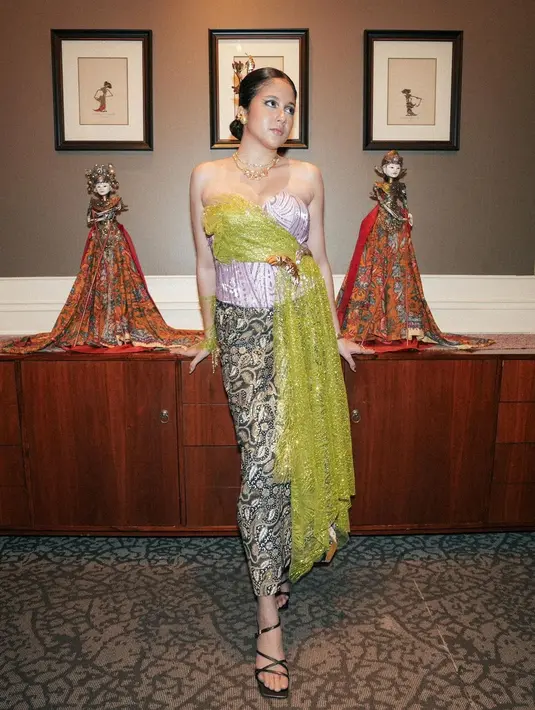 Dipadukan dengan kain batik berwarna hijau keemasan dan sarung tangan dengan aksen brokat dan fringe.