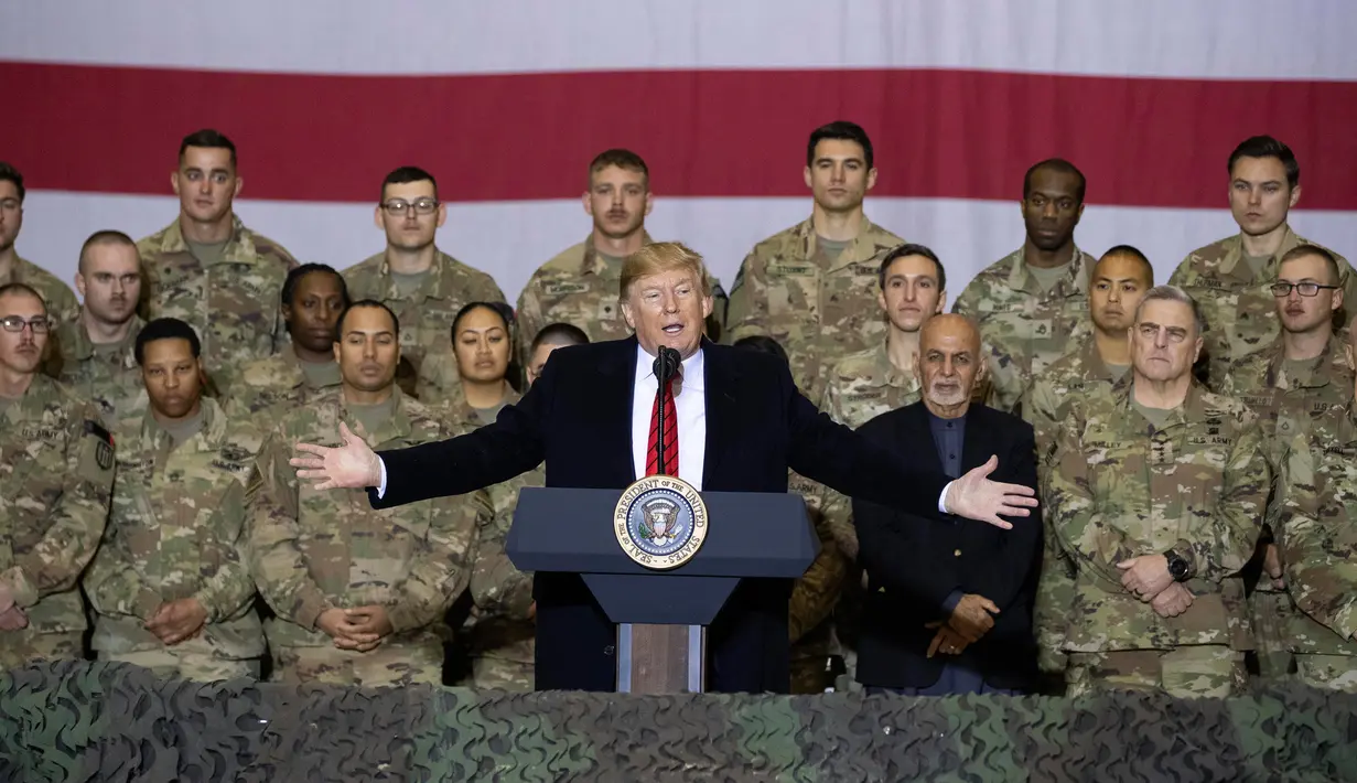 Presiden Amerika Serikat Donald Trump (tengah) didampingi Presiden Afghanistan Ashraf Ghani berbicara kepada anggota militer saat mengunjungi Pangkalan Udara Bagram, Afghanistan, Kamis (28/11/2019). (AP Photo/Alex Brandon)