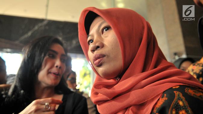 Terpidana kasus pelanggaran ITE Baiq Nuril Maknun (kanan) memberi keterangan saat tiba di Kantor Kemenkumham, Jakarta, Senin (8/7/2019). Guru honorer itu divonis 6 bulan penjara dan denda Rp 500 juta atas perekaman pelecehan seksual yang dialaminya. (merdeka.com/Iqbal Nugroho)