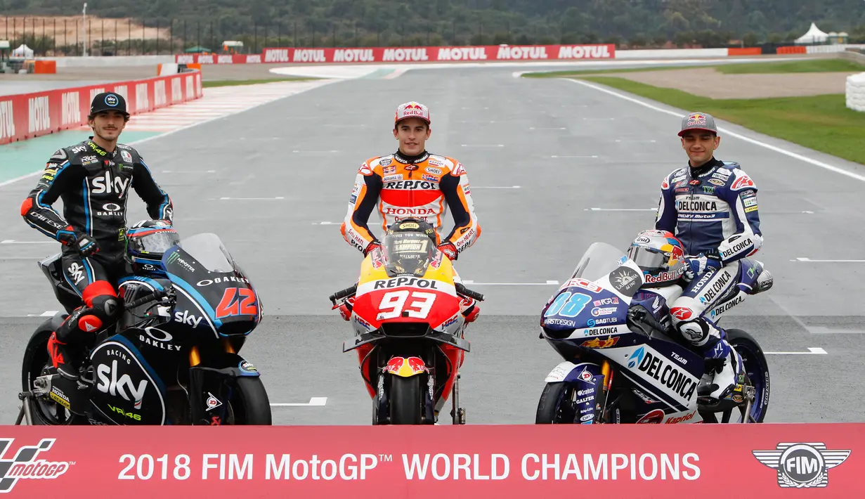 Juara Dunia MotoGP Marc Marquez (tengah) berpose bersama Juara Dunia Moto2 Francesco Bagnaia (kiri) dan Juara Dunia Moto3 Jorge Martin (kanan) usai Grand Prix Valencia di sirkuit Ricardo Tormo, Cheste, Spanyol, Minggu (18/11). (AP Photo/Alberto Saiz)