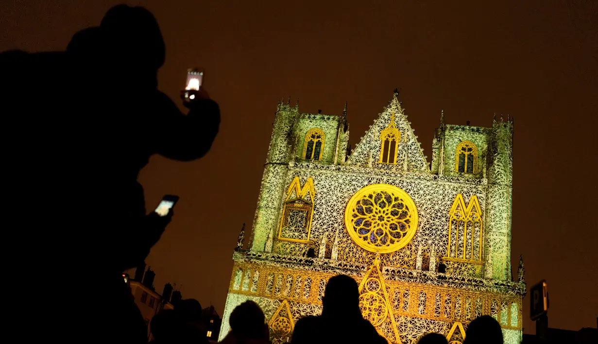 Orang-orang menghadiri pertunjukan cahaya malam di Lyon, Prancis, 8 Desember 2022. Jutaan orang diperkirakan akan menyaksikan acara Festival Cahaya selama empat hari di kota tersebut. (AP Photo/Laurent Cipriani)