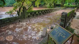 Banjir yang melanda Wilayah Dongxi di Distrik Qijiang, Kota Chongqing, China barat daya (1/7/2020). Guyuran hujan telah menyebabkan peningkatan debit air ke sungai-sungai di daerah pusat kota, dan beberapa pagar pengaman di sepanjang sungai rusak oleh derasnya arus air. (Xinhua/Chen Xingyu)