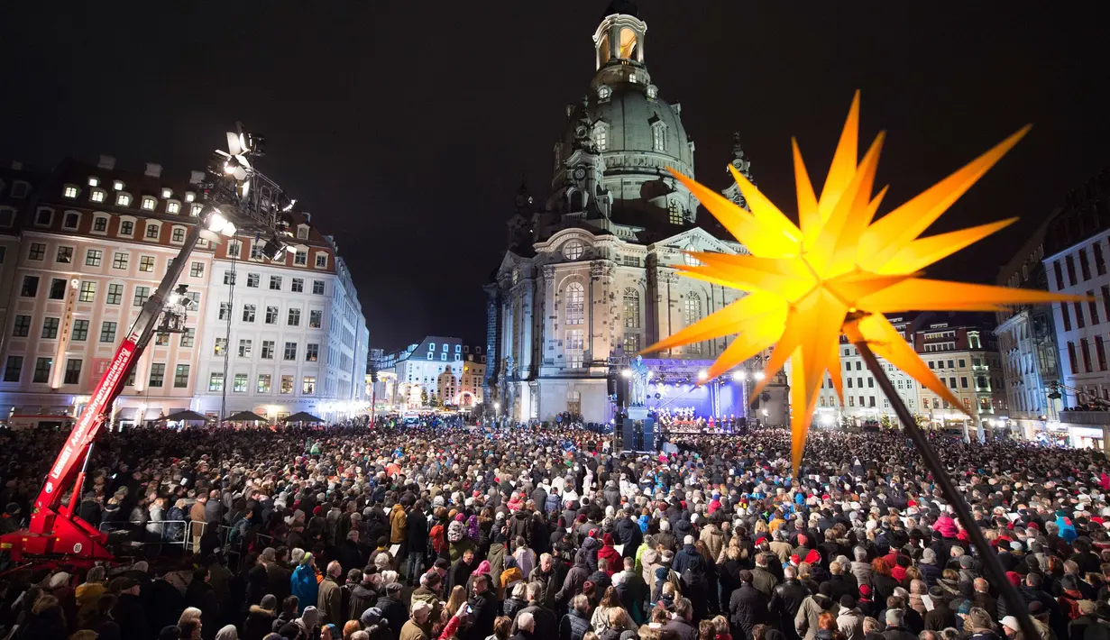 Ribuan orang menonton vespers Natal tradisional di luar gereja Frauenkirche, Church of Our Lady, di Dresden, Jerman (23/12). (Sebastian Kahnert / dpa via AP)