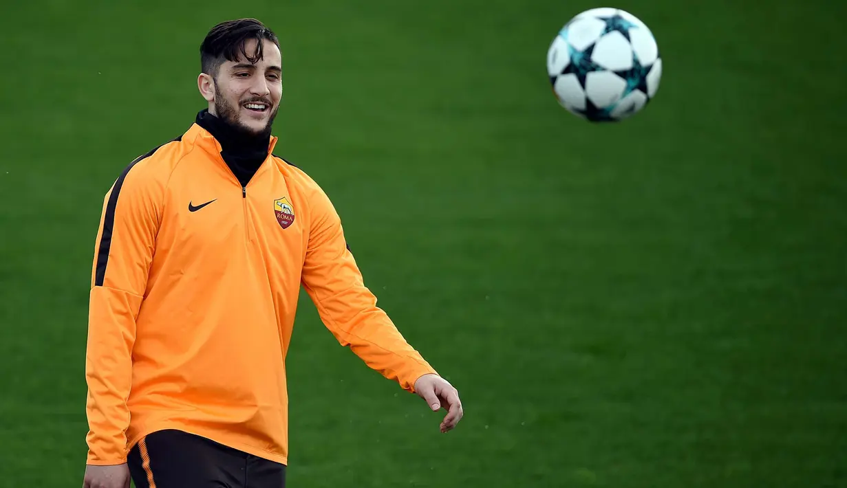 Bek AS Roma, Kostas Manolas tersenyum sambil menendang bola saat latihan di tempat latihan Trigoria di kota Roma (12/3). Pada Leg pertama 16 besar Liga Champions, Roma kalah 2-1 di kandang Shakhtar Donetsk. (AFP Photo/Filippo Monteforte)
