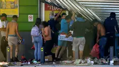 Warga menjarah sebuah supermarket di Puente Alto, wilayah metropolitan Santiago, Chile, Minggu (20/10/2019). Bentrokan pecah di Santiago setelah dua orang tewas ketika sebuah supermarket dibakar ketika protes terhadap kondisi ekonomi dan ketidaksetaraan sosial. (DRAGOMIR YANKOVIC/ATON CHILE/AFP)