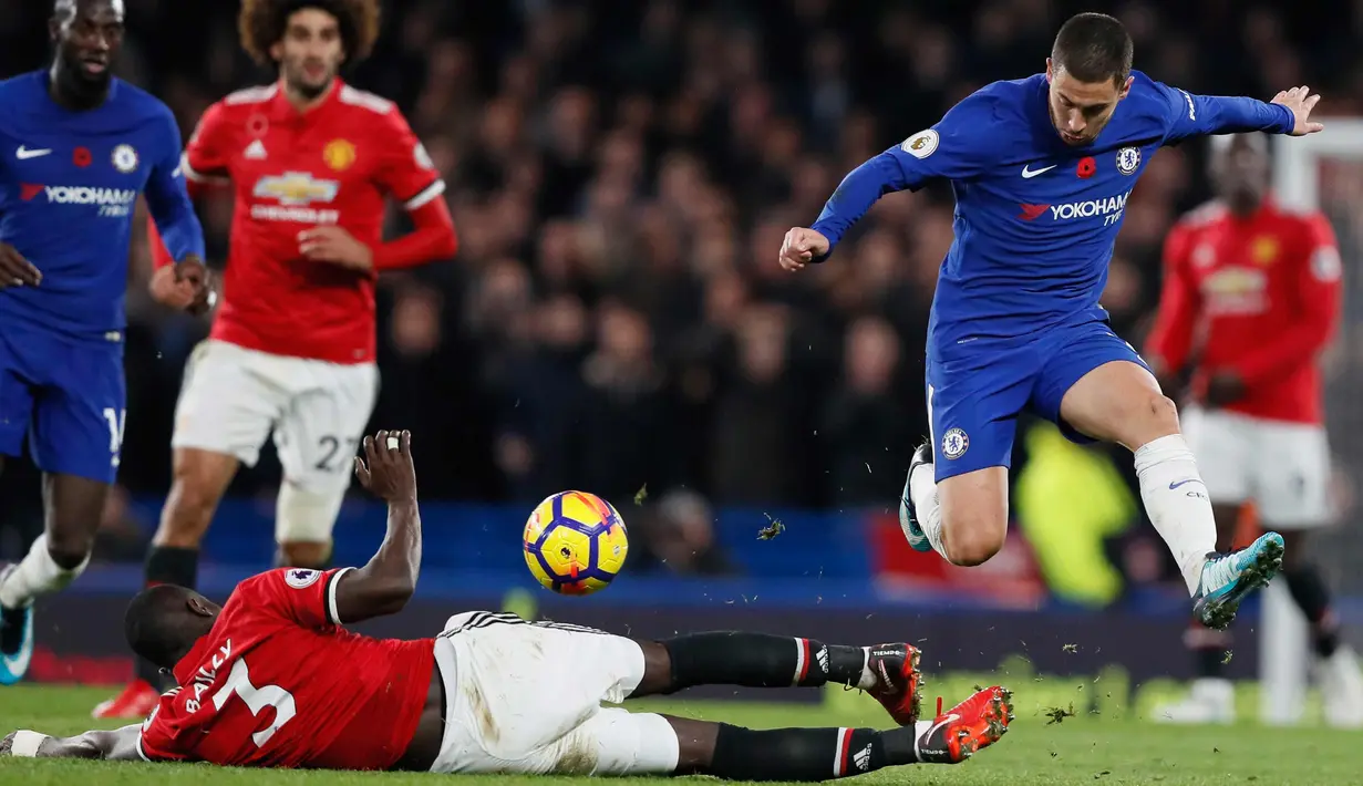 Gelandang Chelsea, Eden Hazard berusaha melewati bek MU, Eric Bailly saat bertanding pada lanjutan Liga Inggris di Stamford Bridge di London (5/11). Chelsea Menang tipis atas MU 1-0. (AP Photo/Kirsty Wigglesworth)