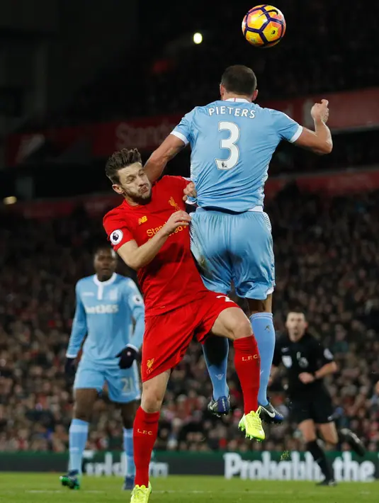 Gelandang Liverpool, Adam Lallana berebut bola udara dengan bek Stoke City, Erik Pieters pada pertandingan Liga Inggris di Anfield, Liverpool, (28/12). Liverpool menang telak atas Stoke dengan skor 4-1. (Reuters/Darren Staples)
