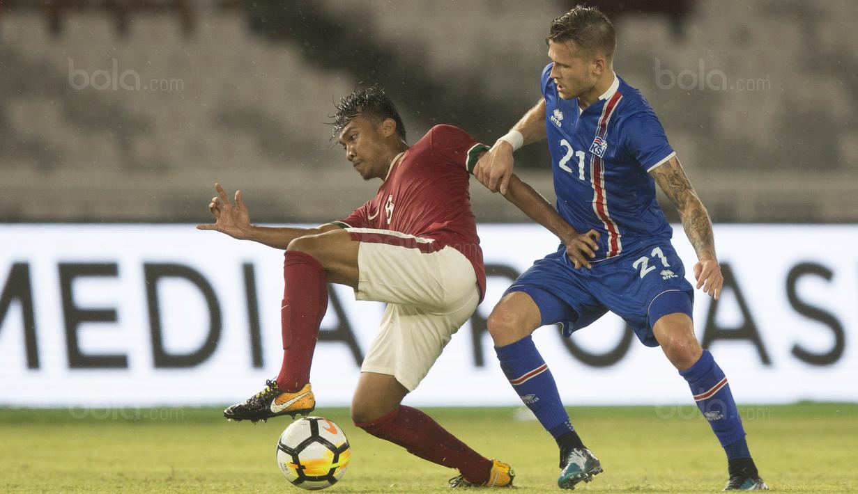 Gelandang Timnas Indonesia, Muhammad Hargianto, berusaha melewati gelandang Islandia, Arnor Traustason, pada laga persahabatan di SUGBK, Jakarta, Minggu (14/1/2018). Indonesia kalah 1-4 dari Islandia. (Bola.com/Vitalis Yogi Trisna)