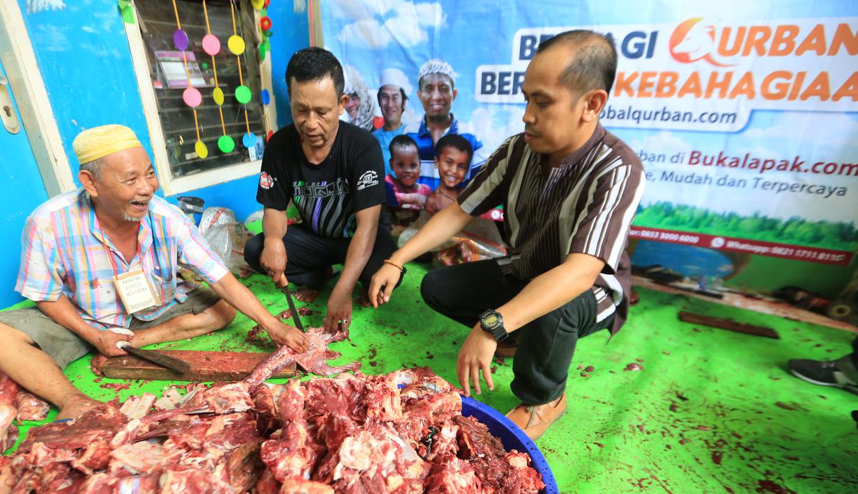 Head of Sales BukaLapak.com Tri Bagus Subekti (kanan) menyaksikan penyembelihan dan distribusi daging qurban di Jakarta, Kamis (24/9). BukaLapak.com bekerjasama dengan Global Qurban dan Aksi Cepat Tanggap (ACT) menyalurkan hewan qurban. (Istimewa)