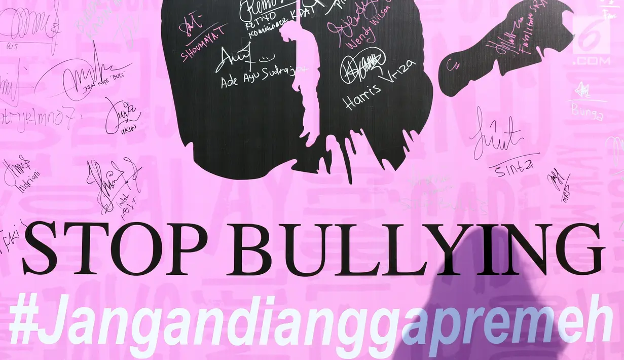 Bayangan warga di depan banner tanda tangan dukungan Stop Bullying saat acara Car Free Day di Kawasan Bundaran Hotel Indonesia, Jakarta, Minggu (13/5). (Liputan6.com/Helmi Fithriansyah)
