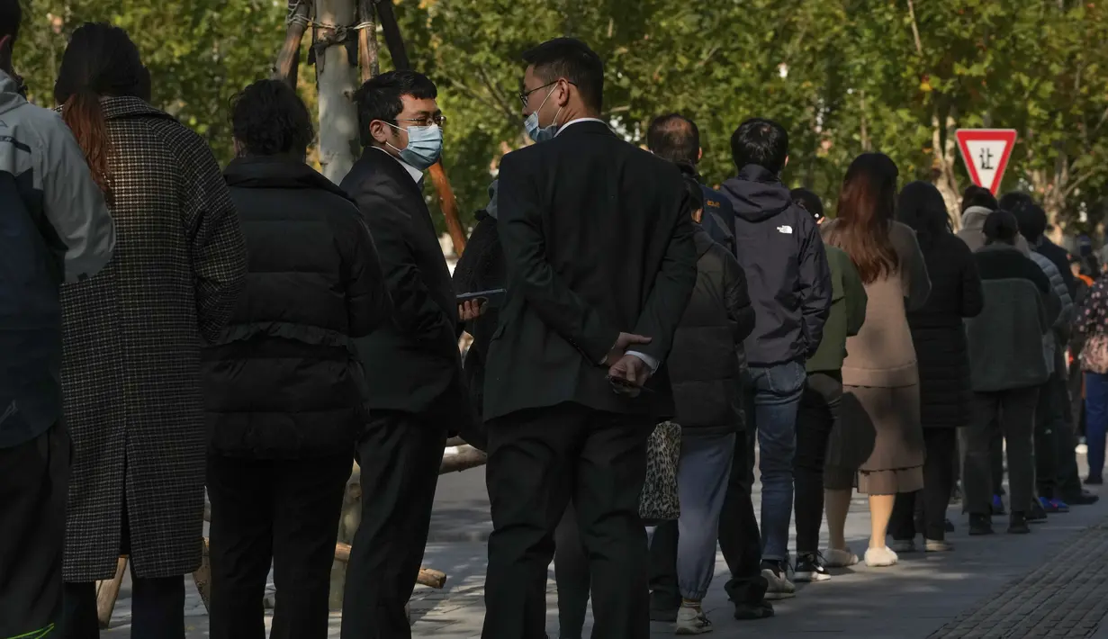 Orang-orang antre untuk melakukan test swab COVID-19 rutin mereka di tempat pengujian virus corona di Beijing, Selasa (8/11/2022). Polisi di timur laut China mengatakan tujuh orang telah ditangkap menyusul bentrokan antara penduduk dan pihak berwenang yang memberlakukan pembatasan karantina COVID-19. (AP Photo/Andy Wong)