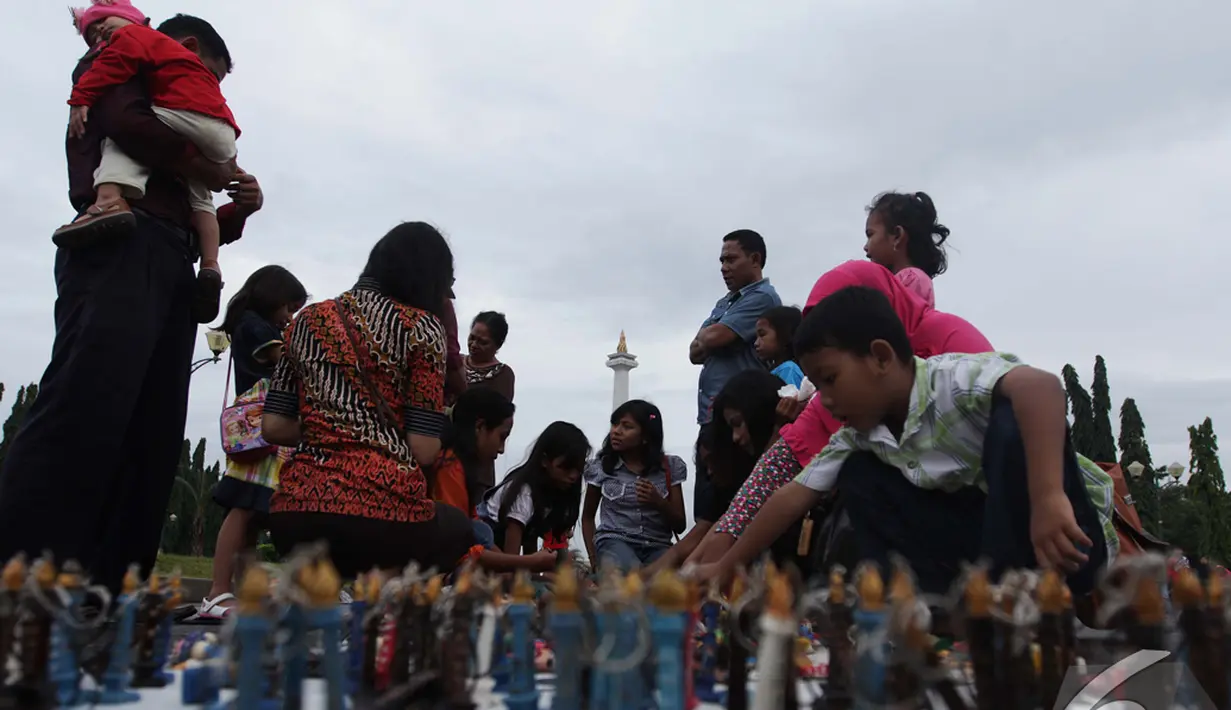 Penjual cinderamata berbentuk tugu Monas ramai dikunjungi pembeli, Jakarta, Kamis (1/1/2015). (Liputan6.com/Faizal Fanani)
