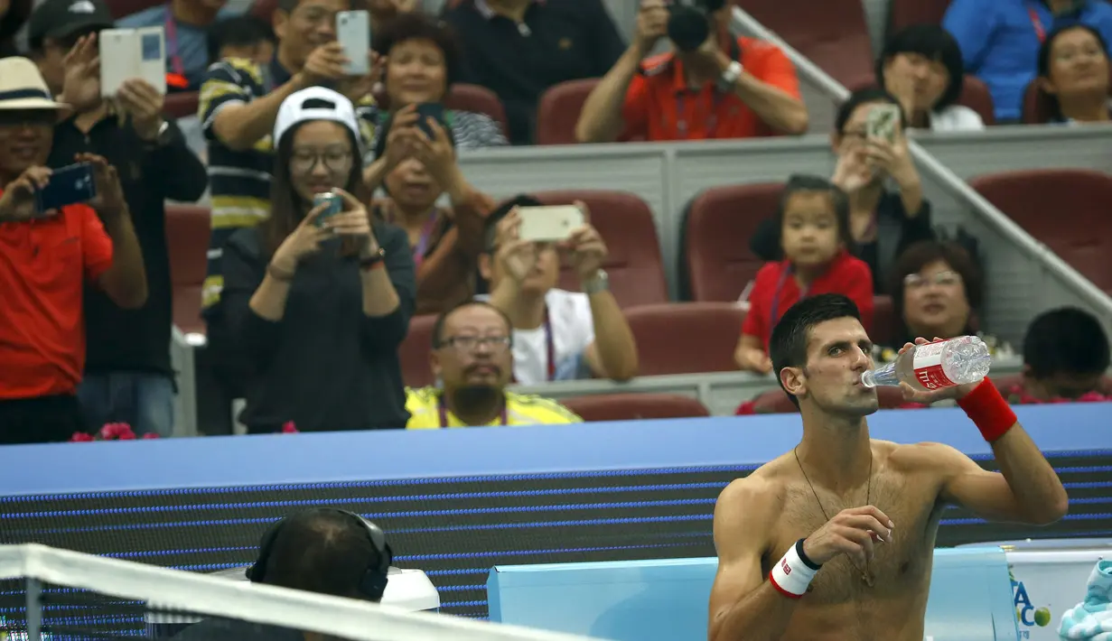 Petenis  Novak Djokovic melepas baju saat berhadapan dengan petenis Italia Simone Bolelli di China Open tennis tournament, Beijing, China, Selasa (06/10/2015).  (REUTERS/Kim Kyung-Hoon)