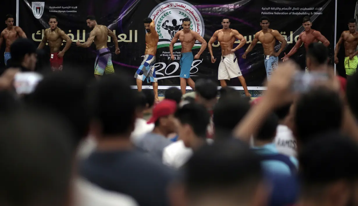Kontestan Palestina memamerkan tubuh berotot pada kompetisi binaraga lokal di Gaza, 26 Oktober 2018. Mereka memamerkan keindahan tubuh berotot di hadapan juri kontes yang diselenggarakan oleh Federasi Binaraga dan Kebugaran Palestina. (AP/Khalil Hamra)