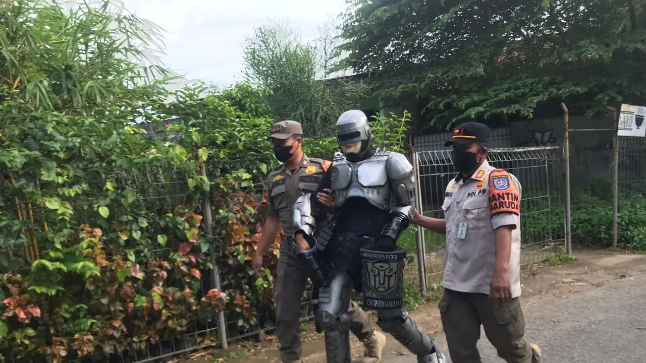 Satpol PP Depok mengamankan PPKS yang mengenakan kostum Robocop di Jalan Juanda, Kota Depok. (Istimewa)