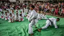 Anak-anak menyaksikan para pelatih bertarung selama upacara promosi Karate di pusat olahraga di kamp Rafah untuk para pengungsi Palestina di Jalur Gaza selatan (20/9/2019). (AFP Photo/Said Khatib)