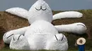Salah satu pengunjung memperhatikan kelinci raksasa yang dipamerkan pada Taoyuan Land Art Festival di Taiwan, (3/9/2014). (REUTERS/Pichi Chuang)