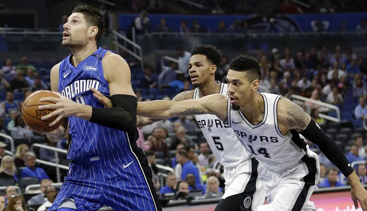 Pebasket San Antonio Spurs, Dejounte Murray dan Danny Green, berusaha merebut bola dari Orlando Magic, Nikola Vucevic, pada laga NBA di Amway Center, Sabtu (28/10/2017). San Antonio Spurs takluk 87-114 dari Orlando Magic. (AP/John Raoux)