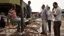 Pembeli bernegosiasi sebelum membeli ikan di sebuah pasar ikan di dekat Sungai Nil, di kota kembar Khartoum, Omdurman (24/6/2019). Khartoum didirikan pada tahun 1821 sebagai pos militer Mesir, namun berkembang menjadi pusat perdagangan regional. (AFP Photo/Yasuyoshi Chiba)