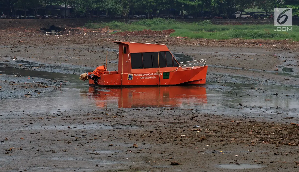 Perahu milik Dinas Kebersihan Pemprov DKI Jakarta berada di tengah Setu Babakan yang sedang surut, Jakarta, Jumat (7/7). Menurut petugas, air sengaja disurutkan terkait proyek pengerukan di sekitar hulu Setu Babakan. (Liputan6.com/Helmi Fithriansyah)
