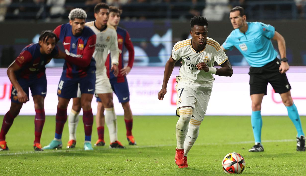 Pemain Real Madrid, Vinicius Junior mencetak gol melalui tendangan penalti ke gawang Barcelona pada laga final Piala Super Spanyol di Stadion King Saud University, Riyadh, Arab Saudi Senin (15/1/2024) dini hari WIB. (AFP/Giuseppe Cacace)
