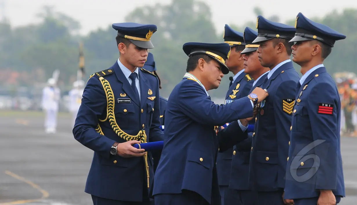 Kepala Staf Angkatan Udara (Kasau) Marsekal TNI Agus Supriatna memberikan piagam penghargaan kepada anggota TNI di peringatan Hari Ulang Tahun ke-69 TNI AU di Pangkalan Udara Halim Perdanakusuma, Jakarta, Kamis (9/4/20015). (Liputan6.com/Herman Zakharia)