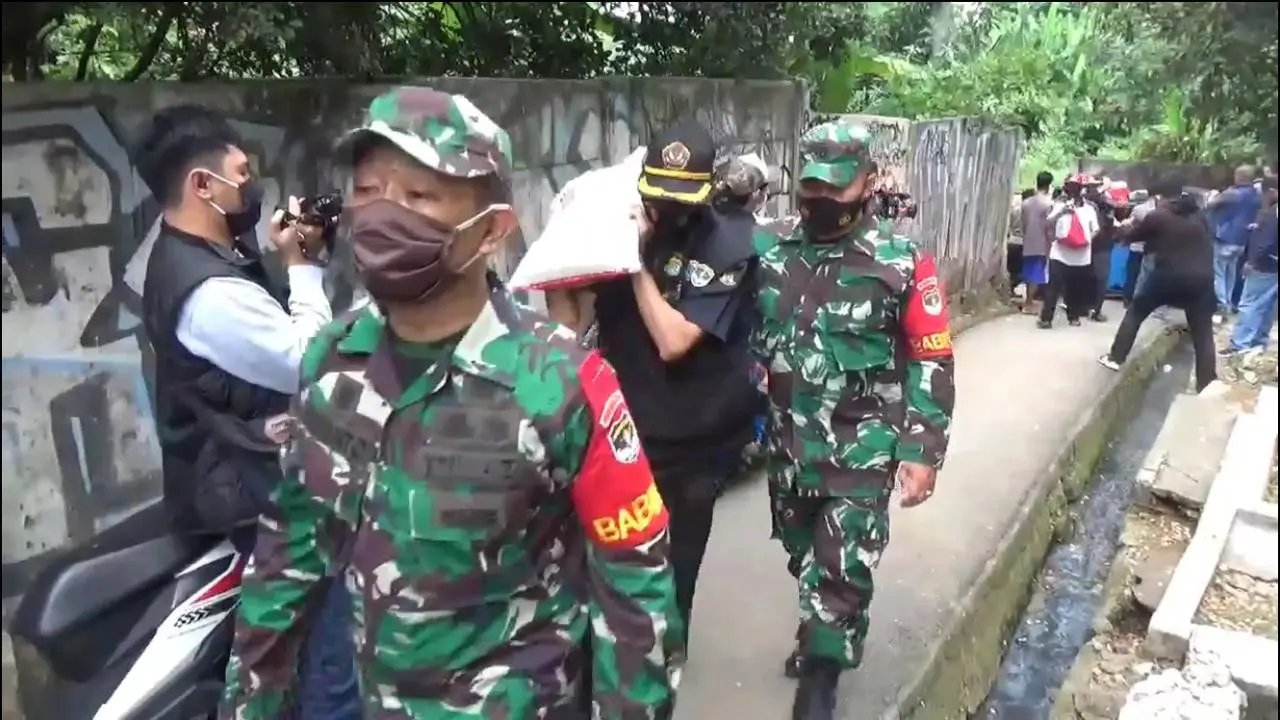 aparat gabungan TNI-Polri membagikan ratusan paket bantuan sosial (bansos) untuk warga yang terdampak Covid-19 di kawasan Lenteng Agung, Cawang, dan Pasar Minggu, Jakarta Timur.