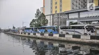 Bus yang mengangkut TKI dari luar negeri mengantre masuk untuk menjalani karantina di RSDC Wisma Atlet Kemayoran, Jakarta, Kamis (16/12/2021). Menkes Budi Gunadi Sadikin mengumumkan temuan kasus varian Omicron dari pekerja kebersihan di RSDC Wisma Atlet Kemayoran. (merdeka.com/Iqbal S. Nugroho)