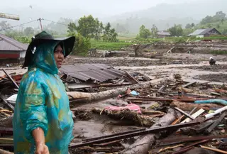 Pemerintah Provinsi Sumatera Utara telah menetapkan status tanggap darurat untuk mempercepat penanganan. Tampak dalam foto, seorang perempuan memeriksa kerusakan akibat banjir di Malalak, Sumatera Barat, Indonesia, Kamis, 27 November 2025. (AP Photo/Ade Yuandha)