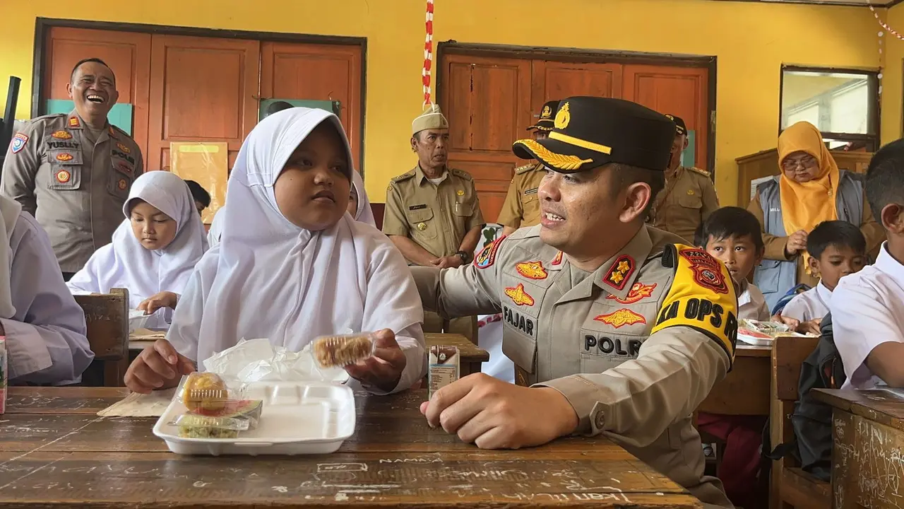 Kapolres Garut, AKBP Mochamad Fajar Gemilang mendamping siswa kampanye program Makan Bergizi Gratis (MBG) pemerintah, kepada ratusan siswa SDN 1 Suci Kaler Karangpawitan. (Liputan6.com/Jayadi Supriadin)