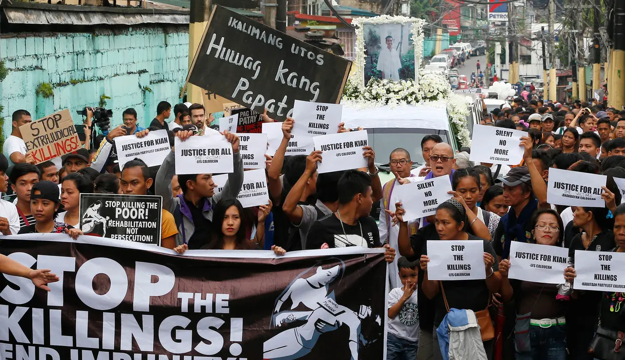 Para pemrotes membawa poster dan spanduk saat mengiringi pemakaman jenazah Kian Loyd delos Santos di Caloocan, Filipina (26/8). Para pemrotes menuntut keadilan untuk kasus penembakan Kian Loyd. (AP Photo/Bullit Marquez)