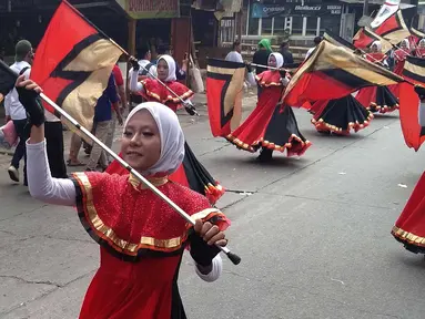 Peserta mengibarkan bendera saat mengikuti pawai taaruf Musabaqah Tilawatil Quran (MTQ) tingkat Kota Tangerang Selatan di Alam Sutera, Serpong Utara, Senin (9/9/2019). Pawai taaruf ini diikuti kecamatan se-Kota Tangerang Selatan. (merdeka.com/Arie Basuki)