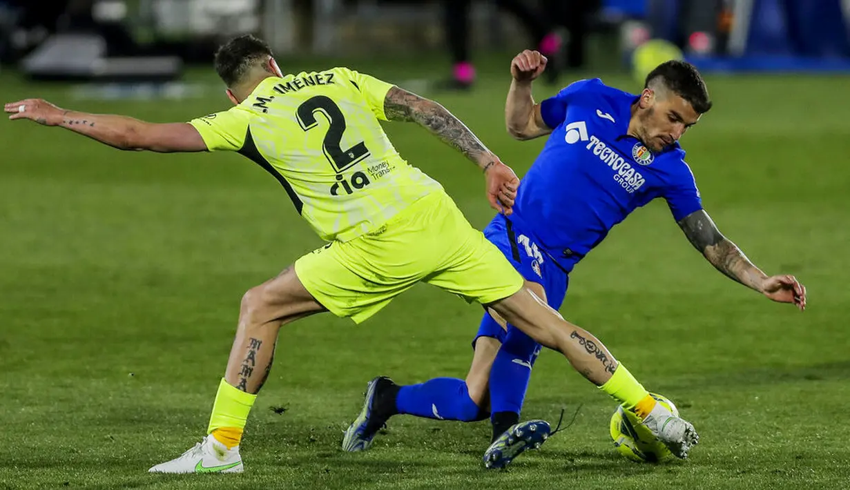 Pemain Atletico Madrid, Jose Gimenez, berebut bola dengan pemain Getafe, Mauro Arambarri, pada laga Liga Champions di Stadion Alfonso Perez, Sabtu (13/3/2021). Kedua tim bermain imbang 0-0. (AP/Manu Fernandez)