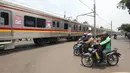 Sejumlah motor berhenti di pintu perlintasan kereta api Bintaro Permai yang tidak berfungsi di Jakarta, Kamis (25/10). Kondisi tersebut sangat membahayakan pengendara yang melintas. (Liputan6.com/Angga Yuniar)