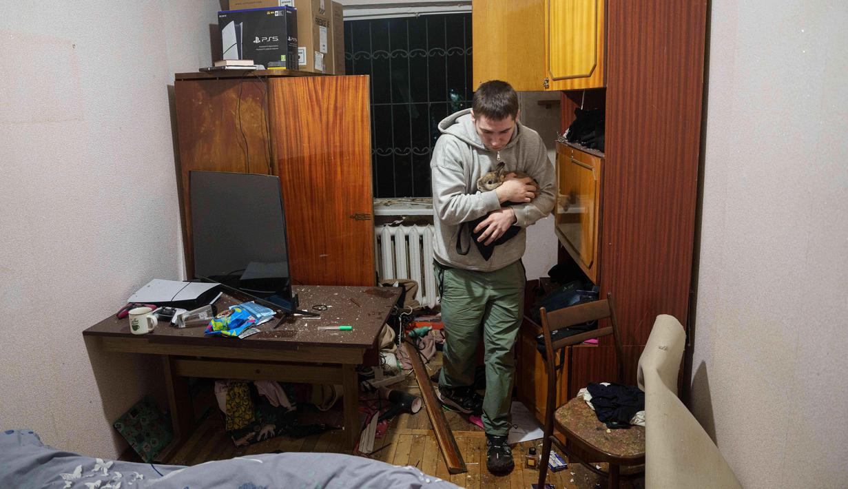 Pada Februari 2026, Kantor Hak Asasi Manusia Perserikatan Bangsa Bangsa (OHCHR) mengonfirmasi terdapat 55.550 korban sipil, 15.378 di antaranya berujung pada kematian. Tampak dalam foto, seorang pria membawa kelincinya ke dalam rumah yang rusak akibat serangan Rusia di daerah pemukiman, Kyiv, Ukraina, pada Kamis 16 April 2026. (AP Photo/Evgeniy Maloletka)