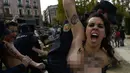 Aktivis Femen ditangkap polisi saat melakukan aksi telanjang dada memprotes penggalian makam diktator Spanyol Francisco Franco selama pertemuan tahunan di Madrid, Spanyol (24/11/2019). Aksi ini sekaligus memperingati kematian ke-44 Francisco Franco. (AFP/Oscar Del Pozo)