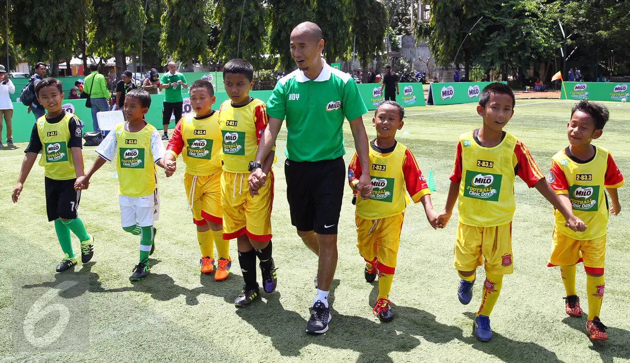 Kurniawan Dwi Yulianto bersama peserta MILO Football Clinic Day memasuki lapangan sepak bola di Lapangan Sepakbola Pertamina-Simprug, Jakarta (29/10). Sebanyak 600 siswa Sekolah Dasar di Jakarta ikut dalam pelatihan sepak bola. (Liputan6.com/Istimewa)