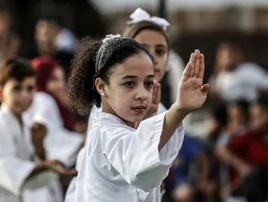 Seorang anak Palestina menunjukkan keterampilannya selama upacara promosi Karate di sebuah pusat olahraga di kamp Rafah untuk pengungsi Palestina di Jalur Gaza selatan (20/9/2019). (AFP Photo/Said Khatib)