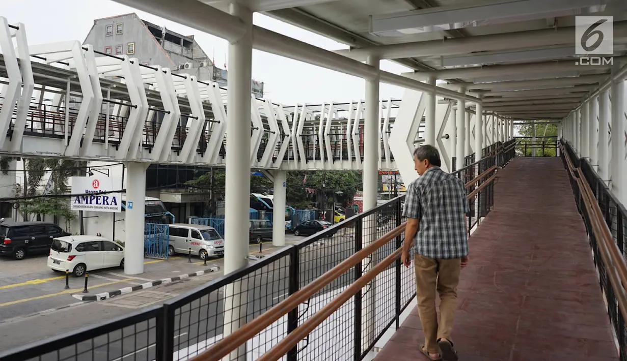 Warga melintasi jembatan penyeberangan (Skybridge) yang menghubungkan Stasiun LRT Velodrome dengan Halte Transjakarta Pemuda di Rawamangun, Jakarta, Senin (29/7/2019). Skybridge ini bertujuan memudahkan integrasi penumpang LRT menuju Transjakarta atau sebaliknya. (Liputan6.com/Immanuel Antonius)