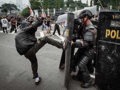 Pengunjuk rasa berusaha menghalangi polisi yang maju dengan perisai selama demonstrasi yang menuntut pembubaran parlemen di depan gedung parlemen Dewan Perwakilan Rakyat di Jakarta pada 25 Agustus 2025. (YASUYOSHI CHIBA/AFP)