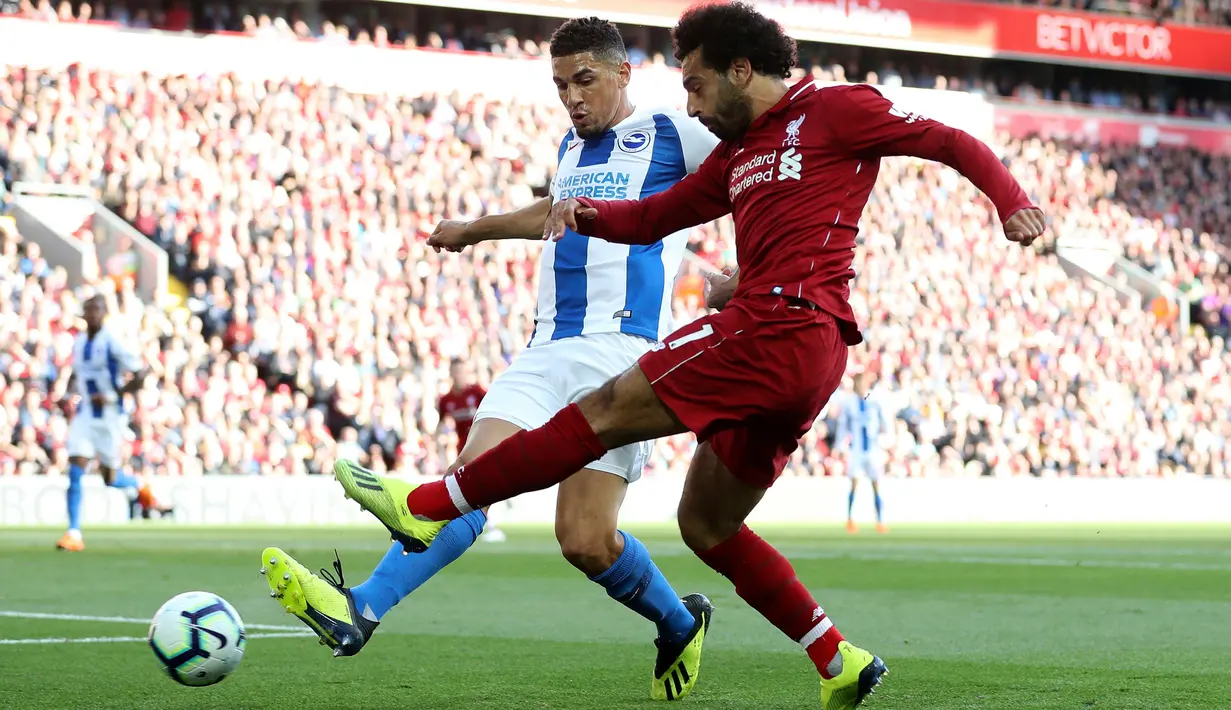 Gelandang Liverpool, Mohamed Salah mengumpan bola dari kawalan pemain Brighton and Hove Albion, Steve Sidwell saat bertanding pada lanjutan Liga Inggris di Anfield Stadium (25/8). Liverpool menang atas Brighton 1-0. (Martin Rickett/PA via AP)